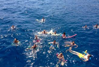 Большая группа студентов языковой школы плавают вместе