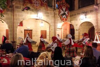 Традиционные мальтийские танцоры выступают на шоу в ресторане